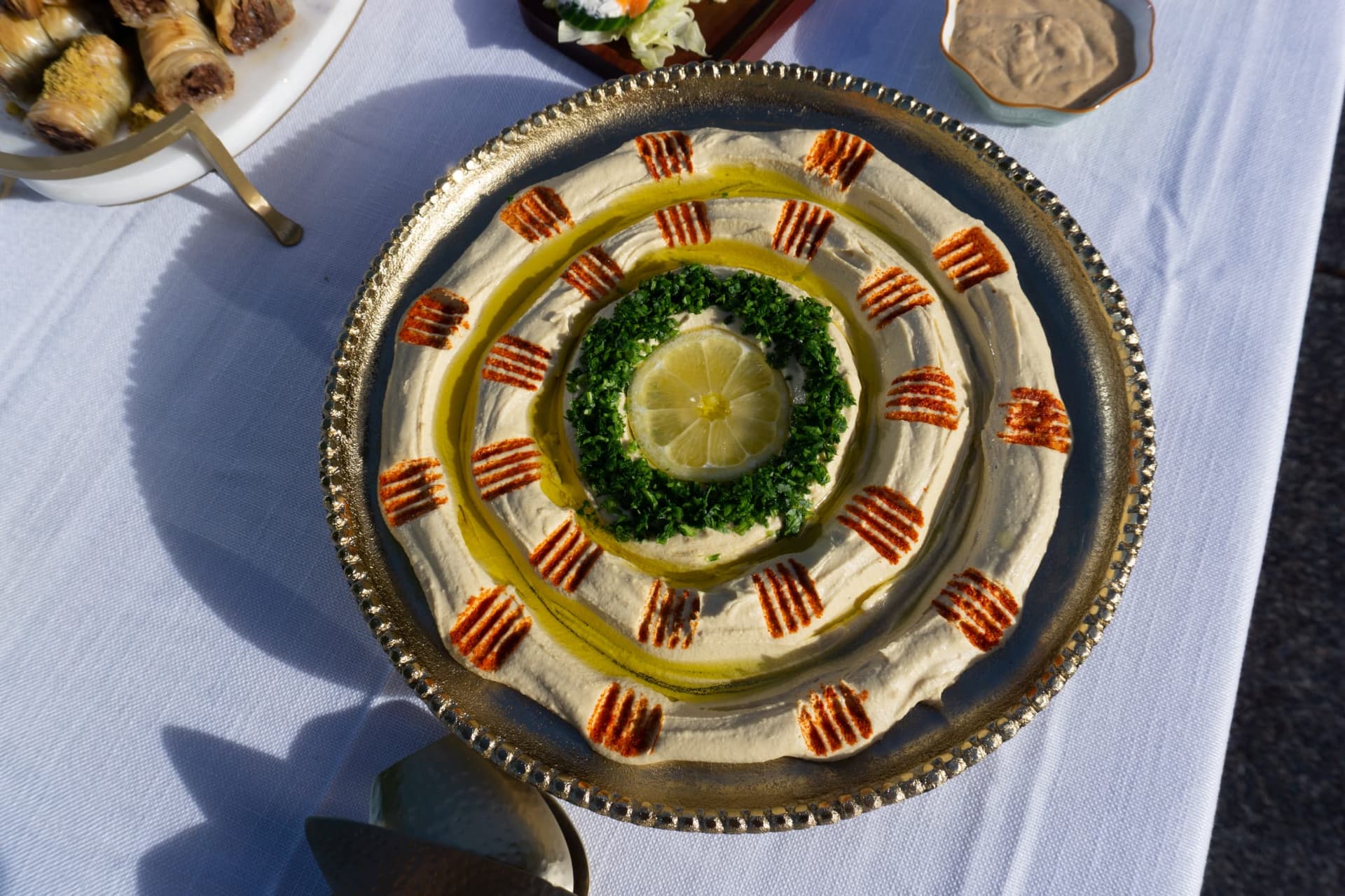 Decorative hummus platter with lemon and herbs