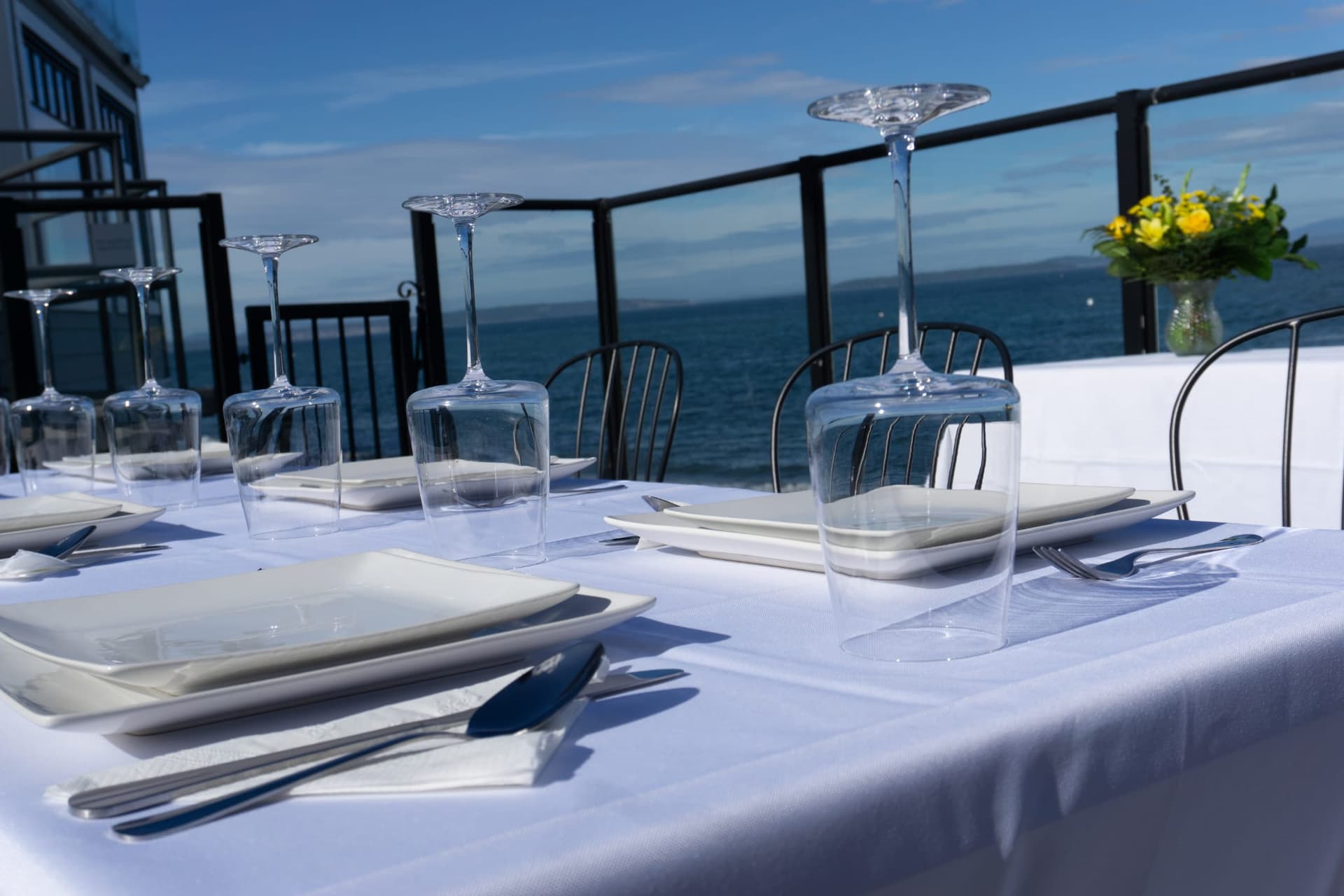 Elegant oceanfront patio table set for a private event